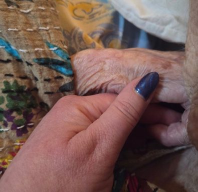 A young hand gently holding an older hand on a patterned surface